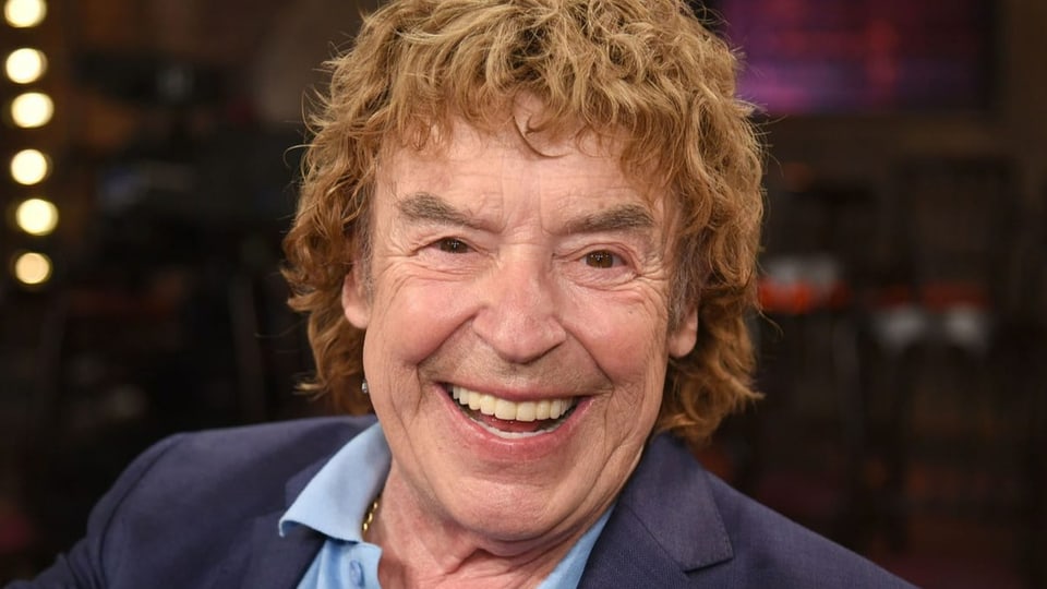 Ein lachender Mann mit braunen Haaren.