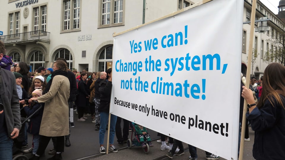 Ein Transparent mit der Aufschrift: Yes we can! Change the system, not the climate!