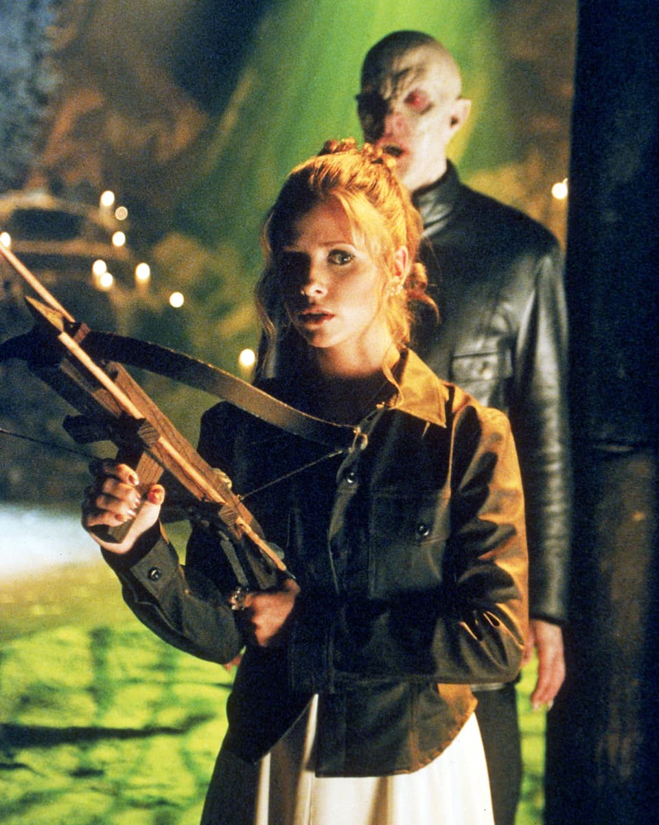 Buffy mit Armbrust, hinter ihr ein Dämon