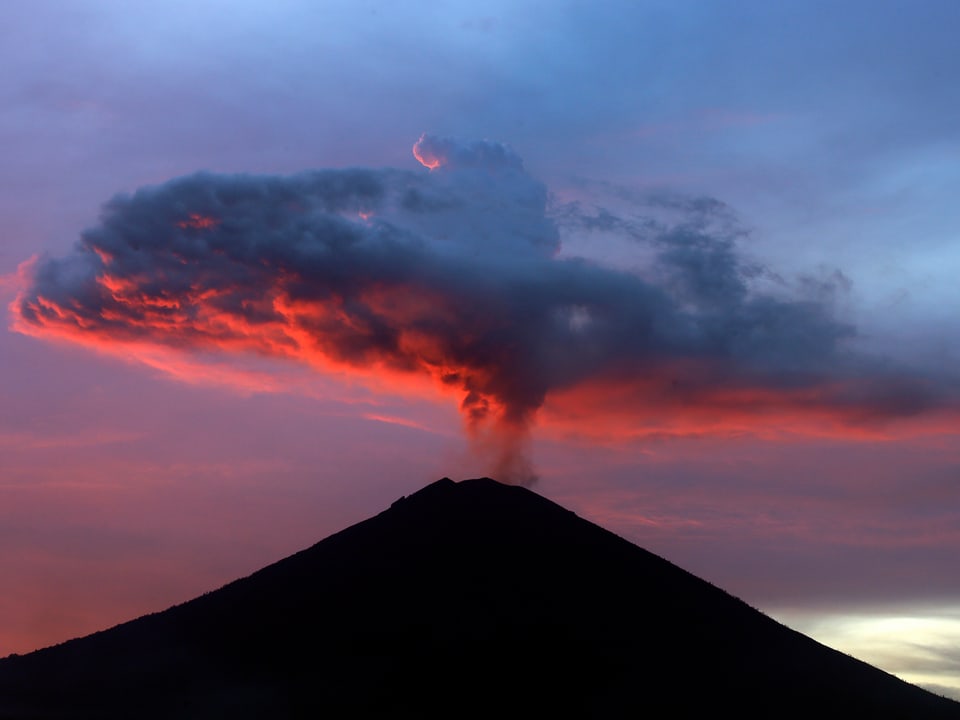 Vulkan im Abendort mit Aschewolke.