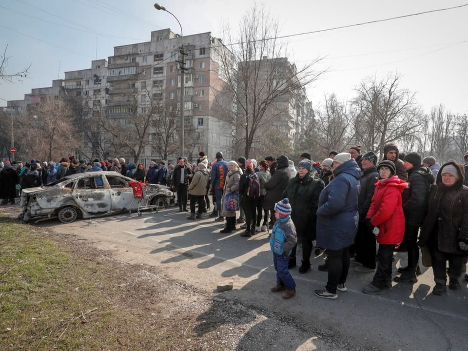Menschen in Mariupol stehen für humanitäre Güter Schlange.