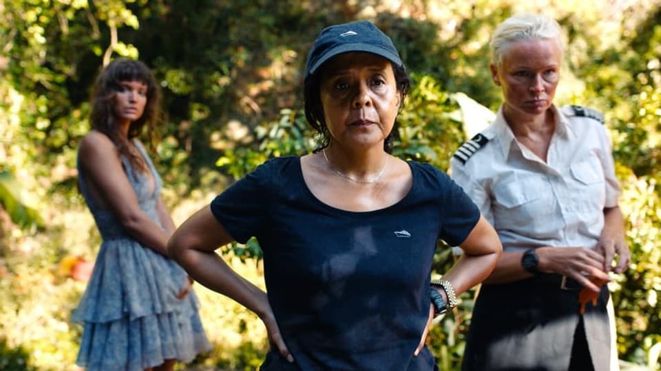 Drei Frauen stehen in einem Regenwald.
