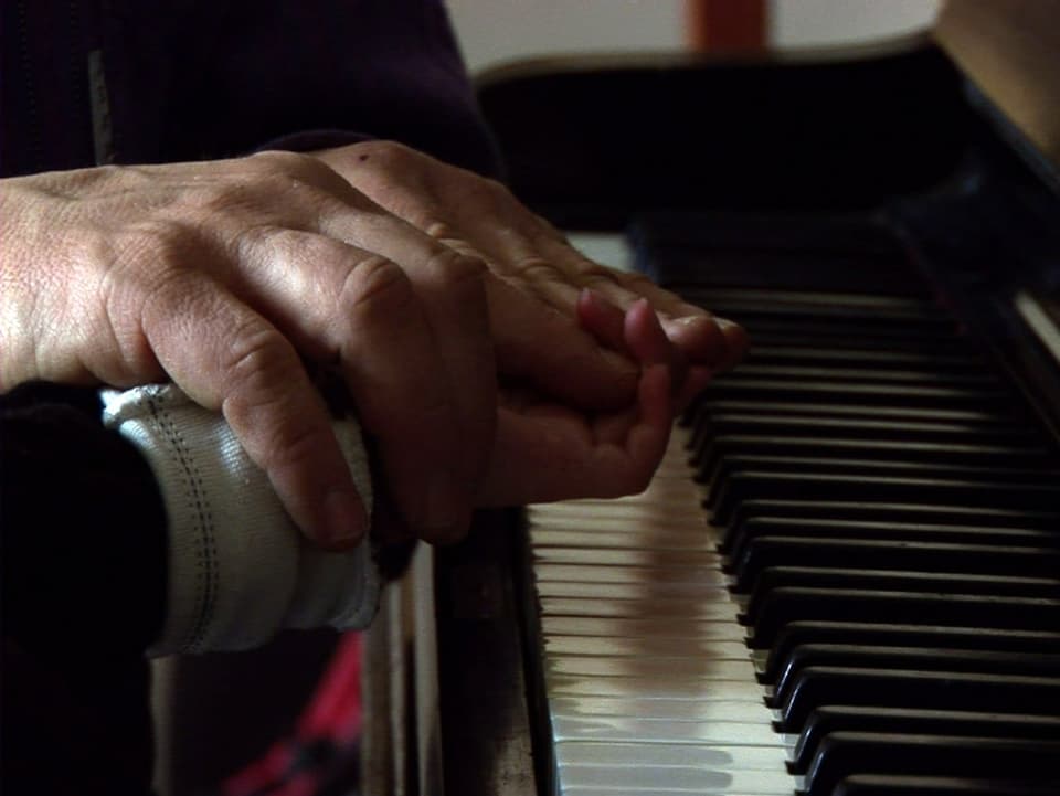 Filmstill: Hände über einer Klaviertastatur.
