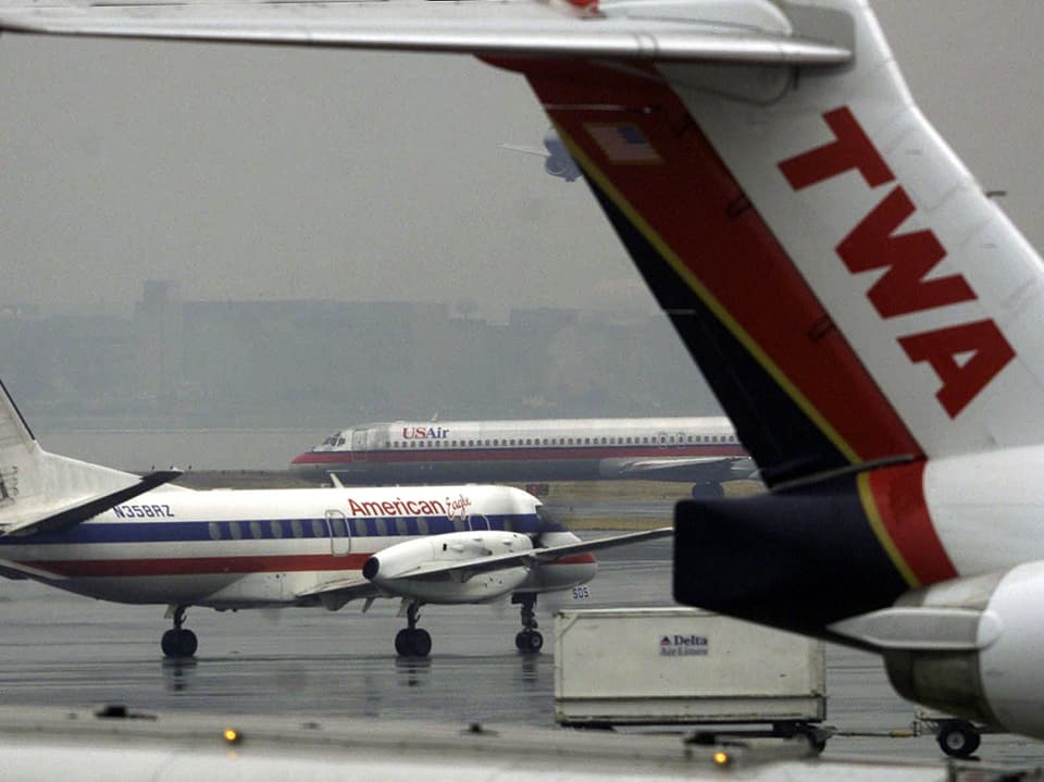 Vordergrund Heckflosse einer TWA-Maschine, Hintergrund Maschine der American Airlines.