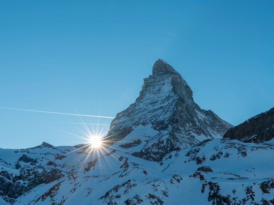 Matterhorn und die Sonne am linken Grat. Blauer Himmel