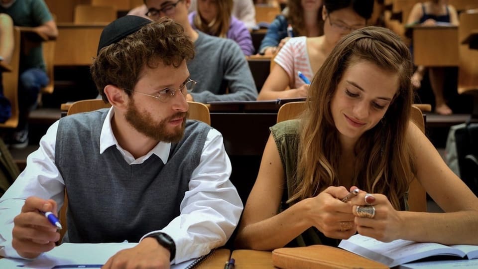 Zwei junge Leute an der Uni sitzen am Tisch