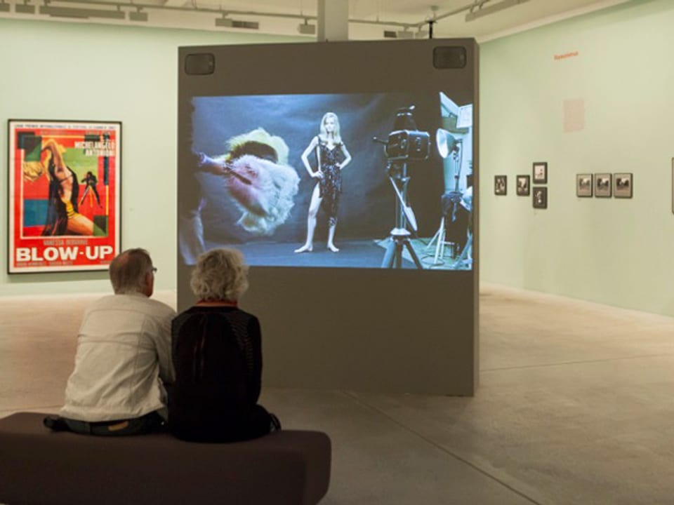 Zwei Besucher im Fotomuseum Winterthur vor einer Leinwand mit einem Filmstill.