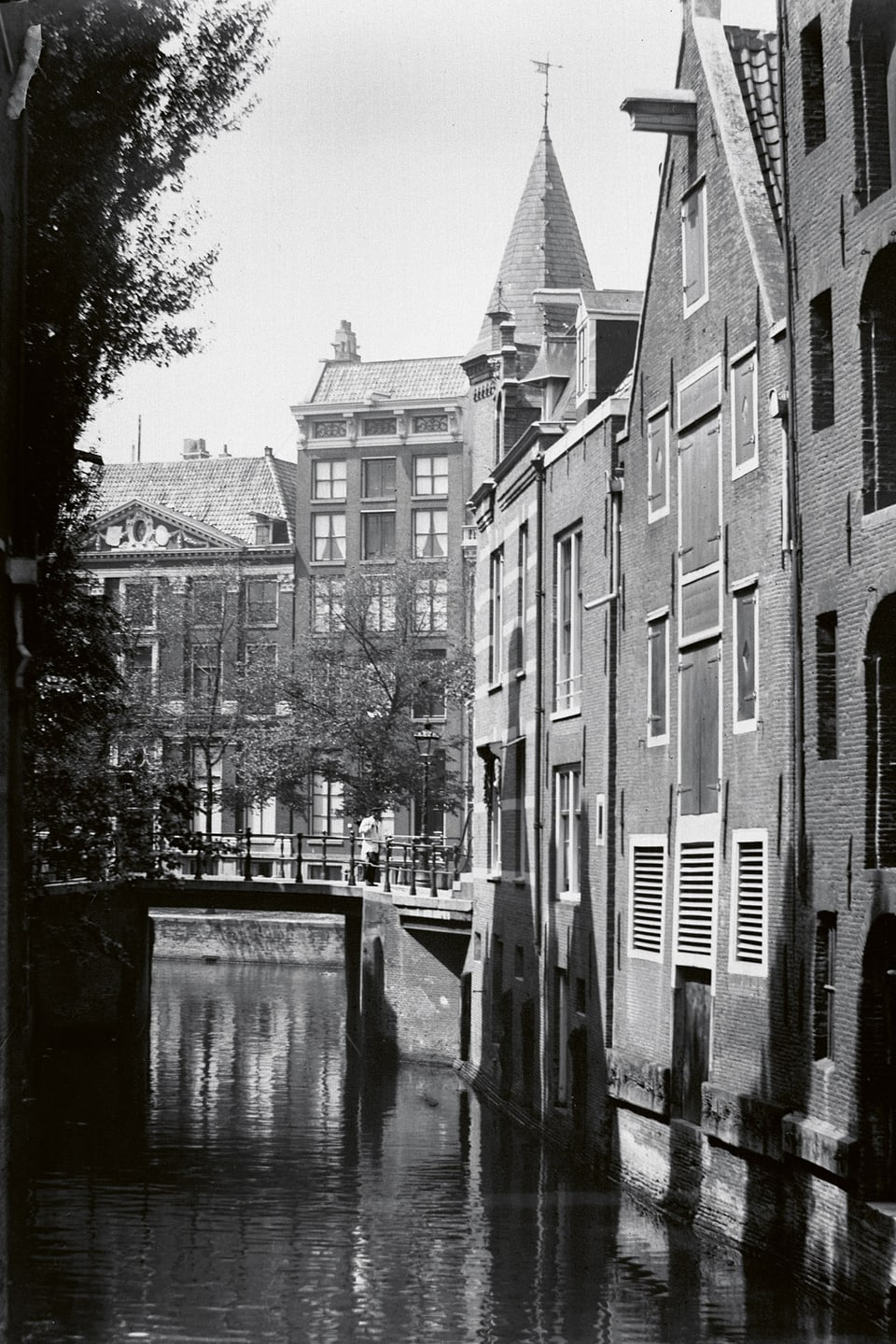 Schwarzweiss-Aufnahme eines Kanals mit Backsteinhäusern.