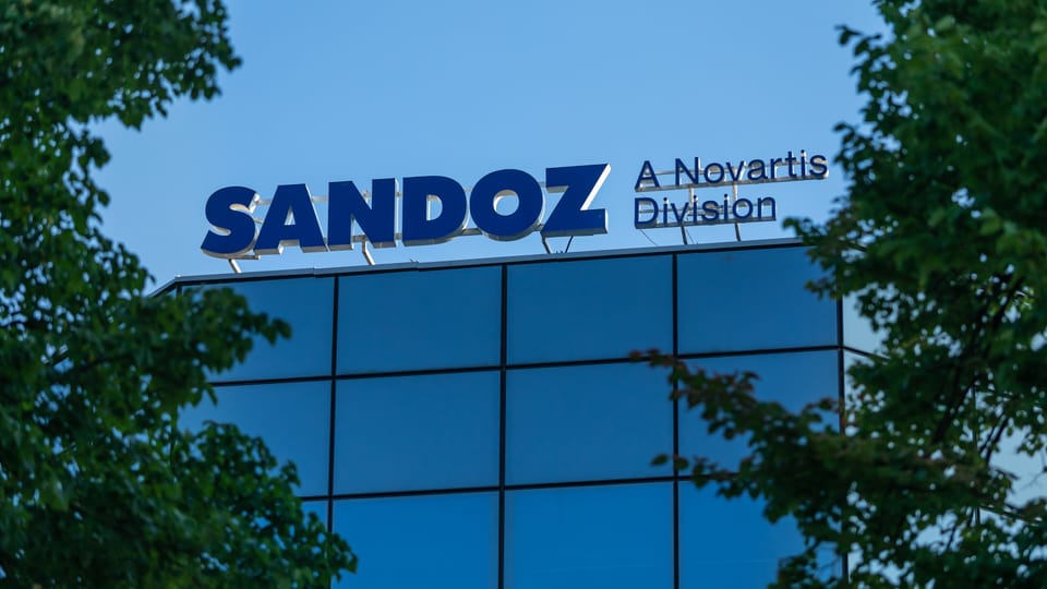 Schild an Gebäude mit Novartis und Sandoz.