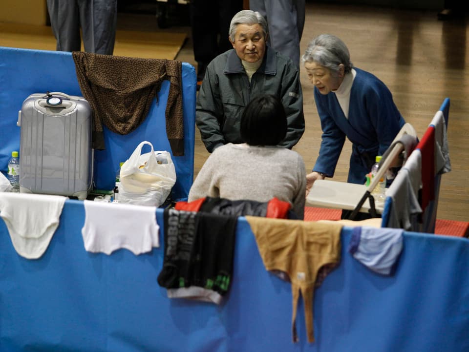 Akihito und Michiko sprechen mit einer Frau.