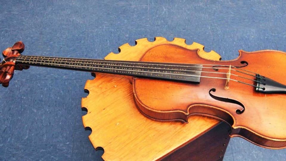 Bratsche mit dem Griffbrett eines Cellos. Auf dem Griffbrett sind kleine Metallnoppen angebracht.