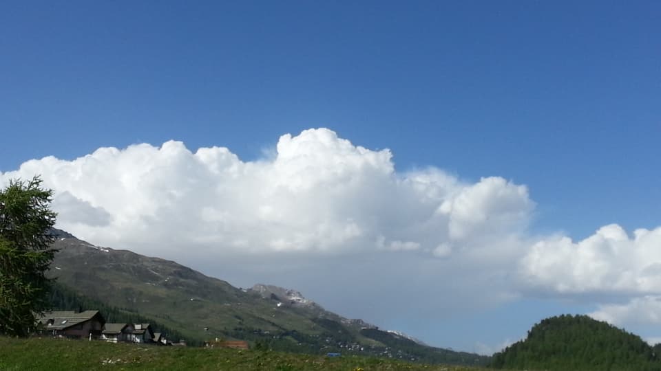Blick von Silvaplana zum Albula. Über den Bergen türmen sich grosse Quellwolken auf.