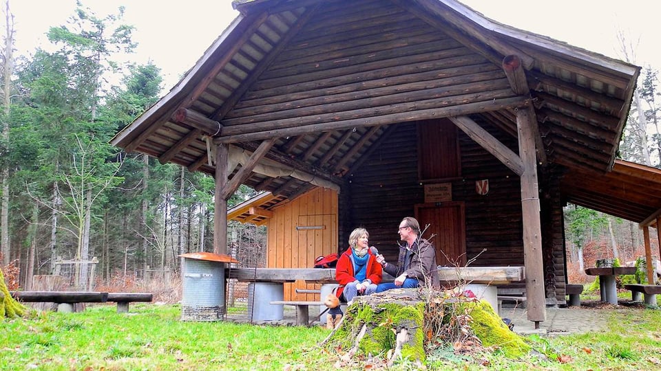 Maya Graf und Christian Zeugin vor einer Waldhütte.