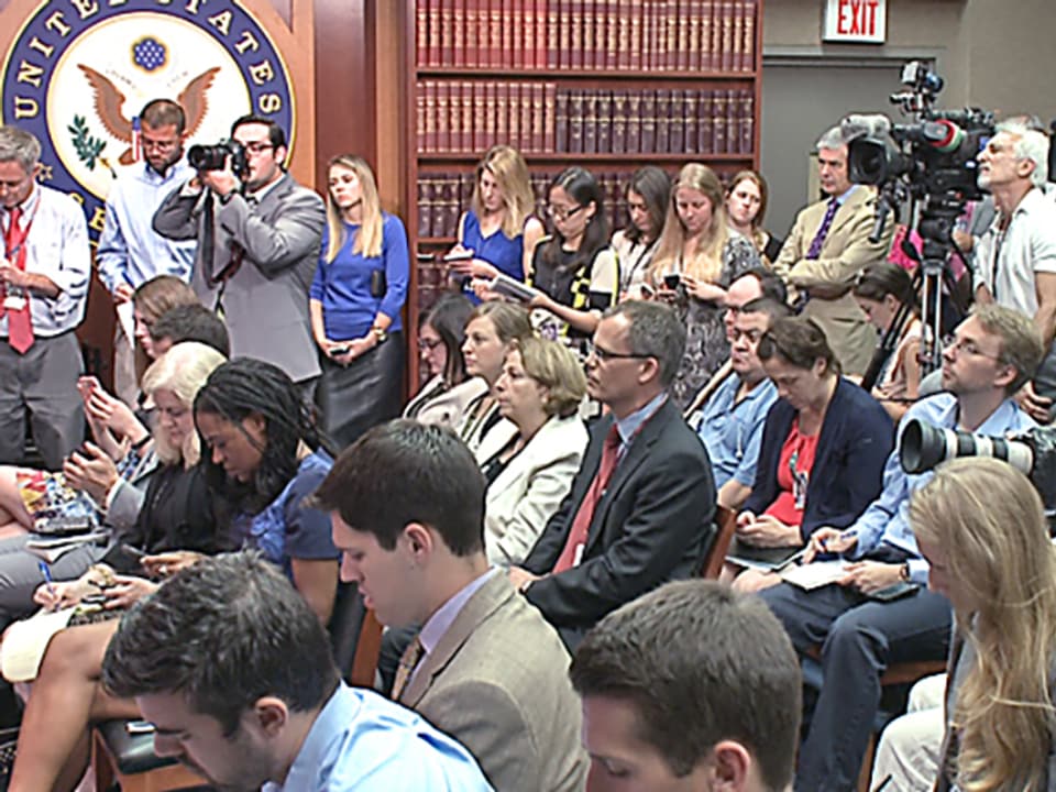 Pressekonferenz, viele Journalisten mit Kameras in einem Raum.