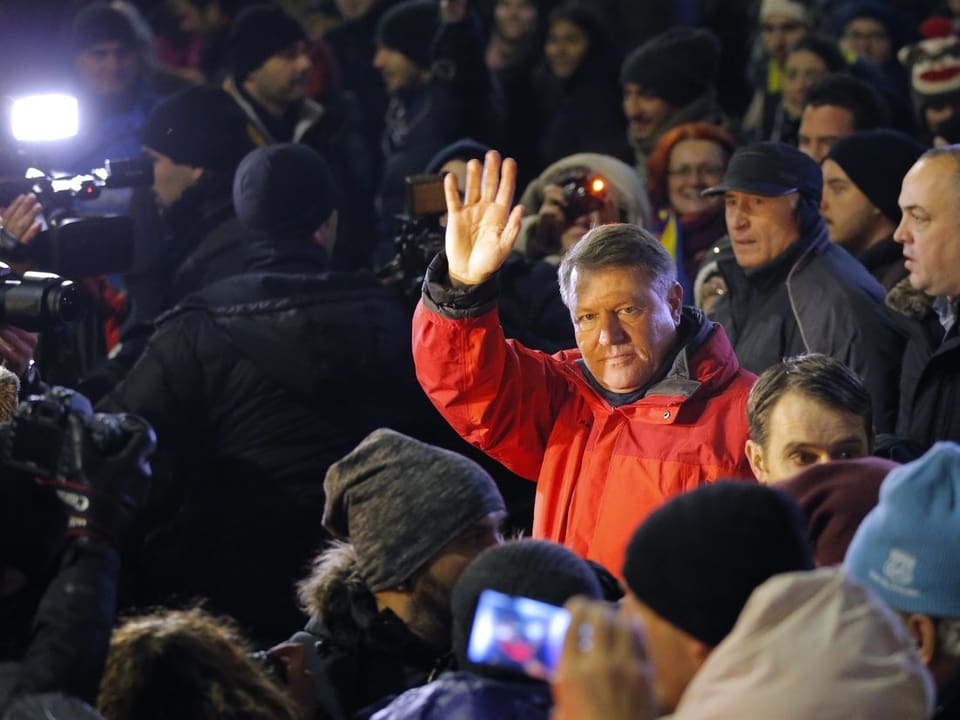 Klaus Iohannis an einer Demonstration in Bukarest. Seine rote Jacke hebt ihn von den anderen Demonstranten ab.