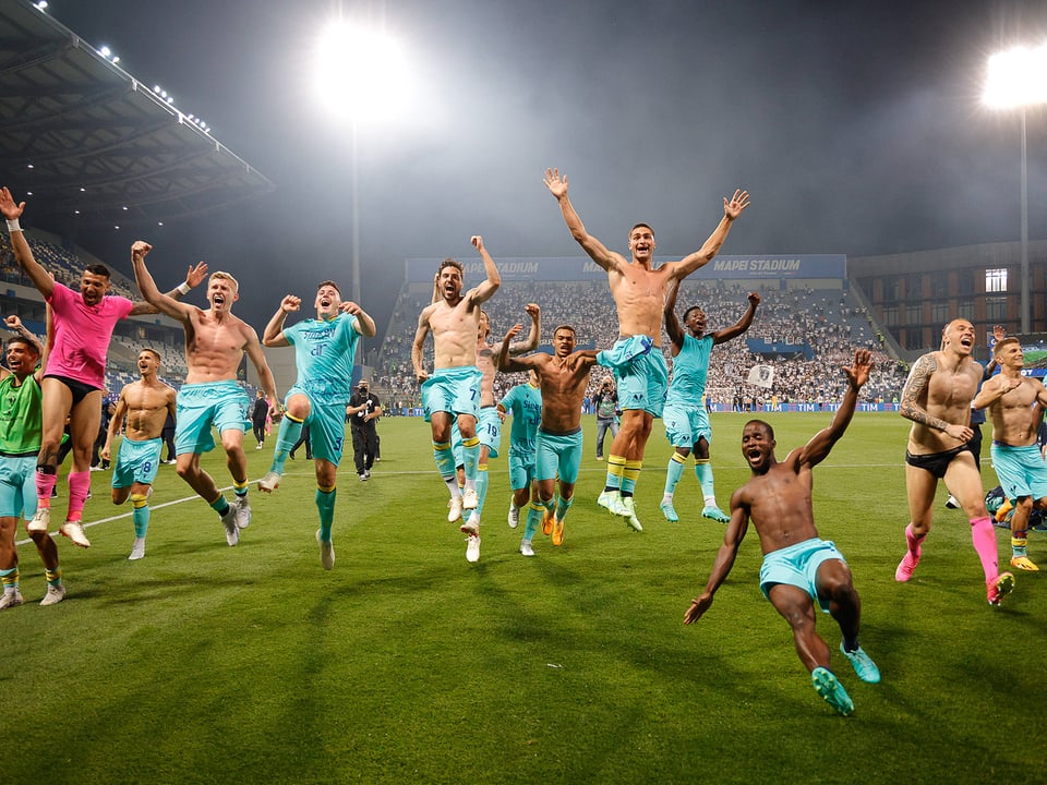 Verona-Spieler springen jubelnd Richtung Fans 