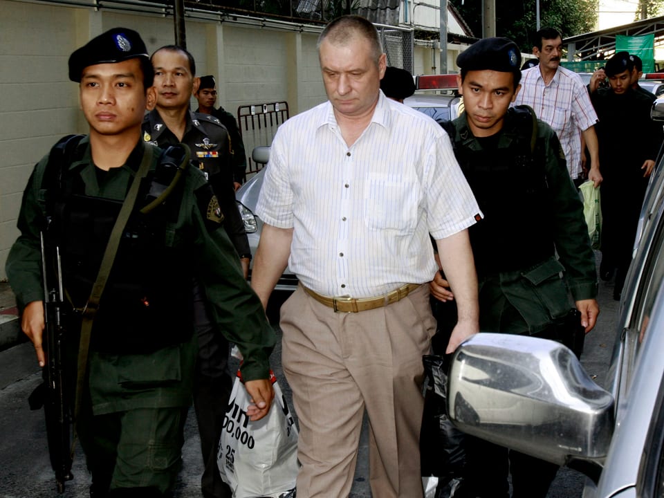 Die thailändische Polizei führt zwei festgenommene Besatzungsmitglieder des Frachtflugzeugs ab.