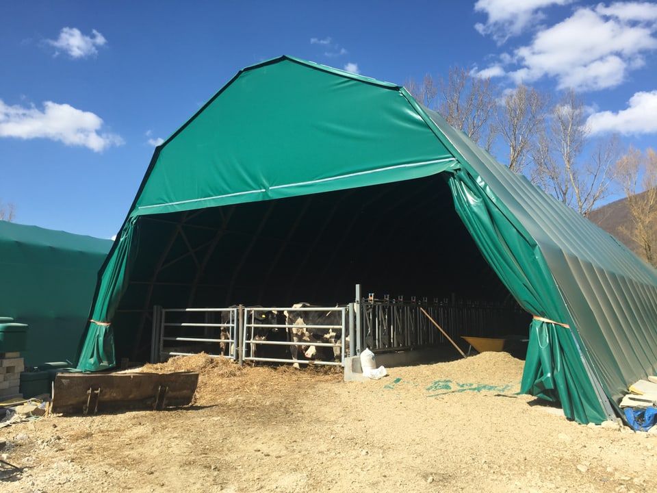 Eingehakter Stall für die Tiere, darüber ein grünes Zelt.