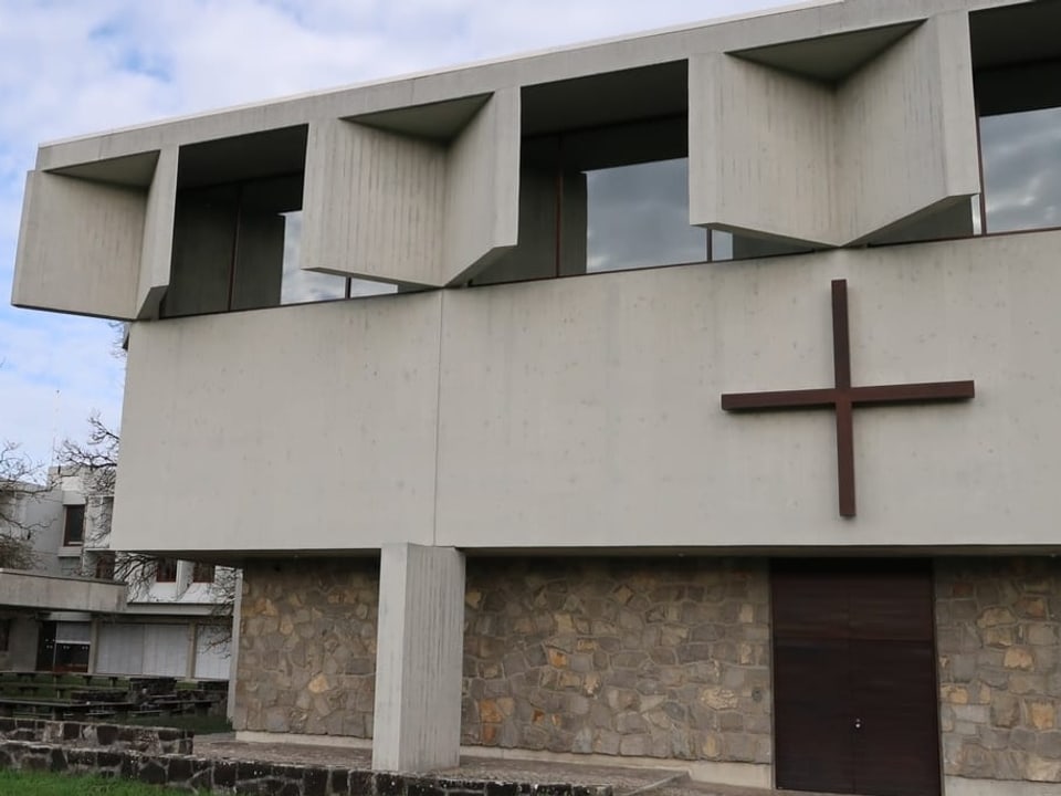 Aussenansicht des Klosters mit EIngang und Kreuz