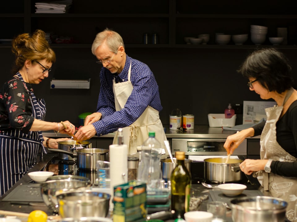 In einer Küche stehen Food-Redaktorin Maja Brunner, René Matter und Michelle Veliu. 