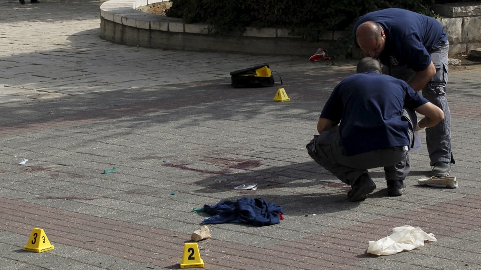 Israelische Polizisten untersuchen den Ort einer Messer-Attacke