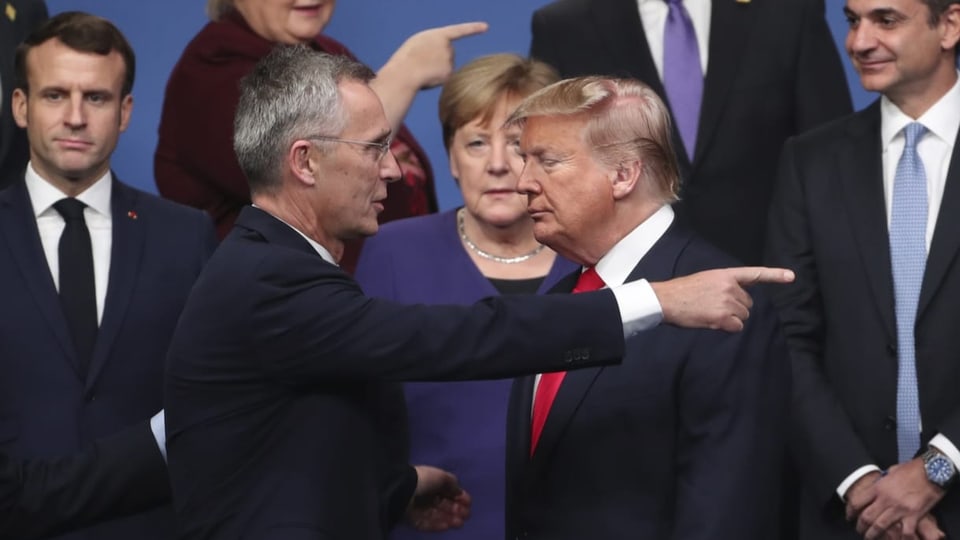 Nato-Chef Jens Stoltenberg weist US-Präsident Donald Trump mit ausgestrecktem Finger den Weg, dieser schliesst die Augen