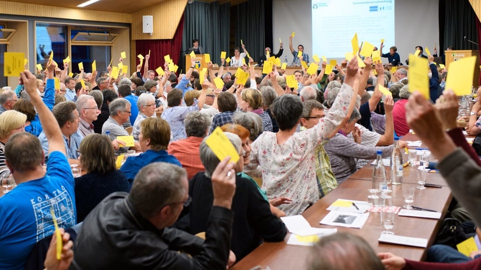 Teilnehmer stimmen während einer Gemeindeversammlung in Kandersteg über ein Geschäft ab. (Symbolbild)