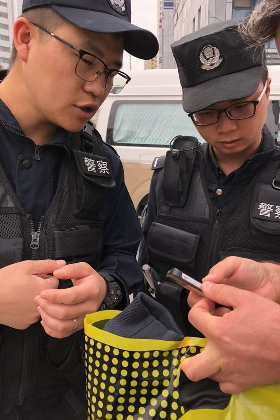 Polzisten schauen auf ein Handy-Display.
