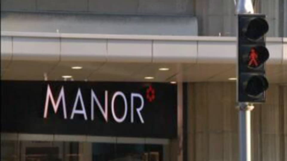 Manor-Schriftzug mit roter Ampel