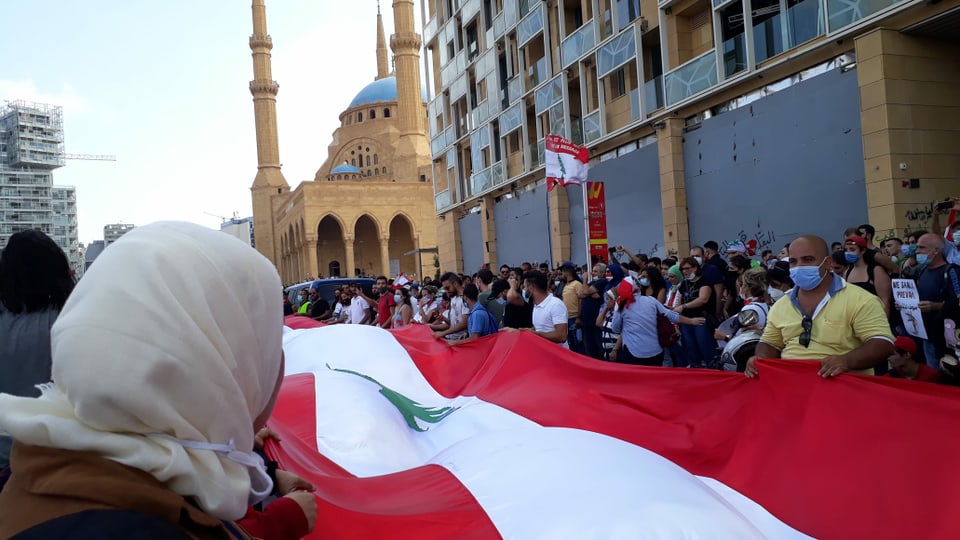 Demonstranten tragen riesige libanesische Fahne