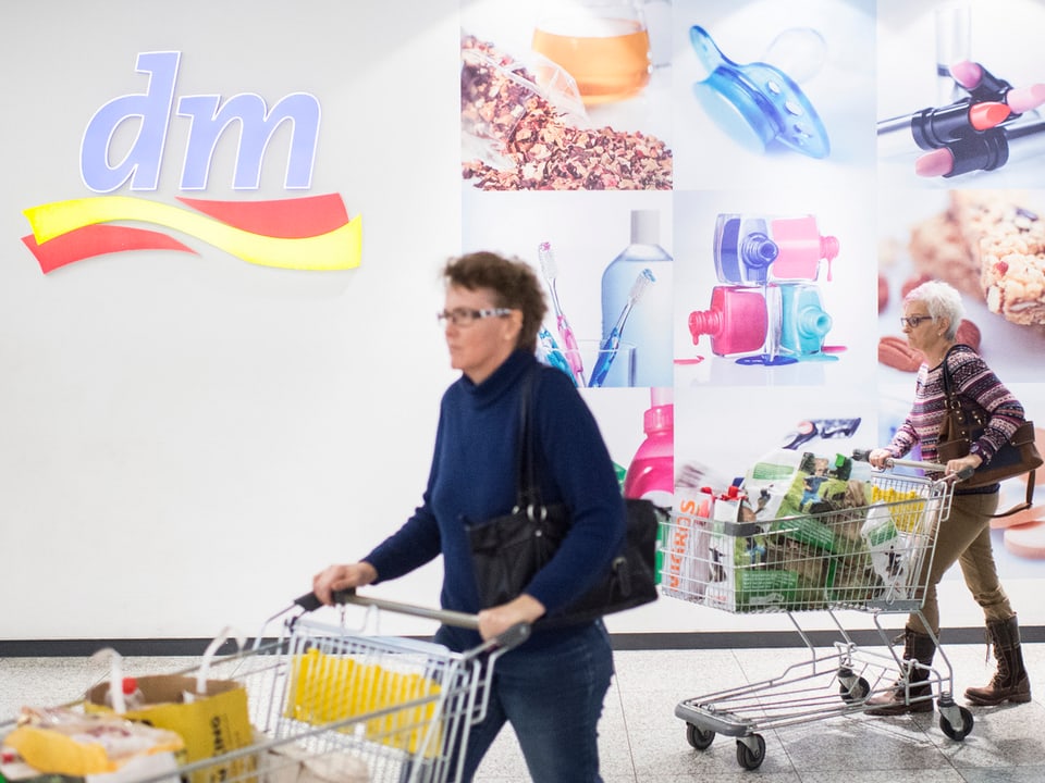Zwei Frauen stossen ihre vollgepackten Einkaufswagen aus der DM-Filiale im Einkaufszentrum Lago in Konstanz. (keystone)