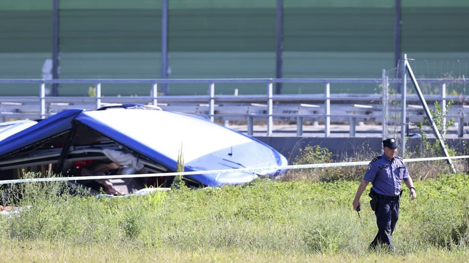 Ein Polizist geht neben dem Wrack eines Busses an der Unfallstelle in Podvorec, in der Nähe von Zagreb, Kroatien