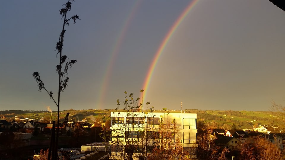 Ein doppelter Regenbogen über einem Haus.