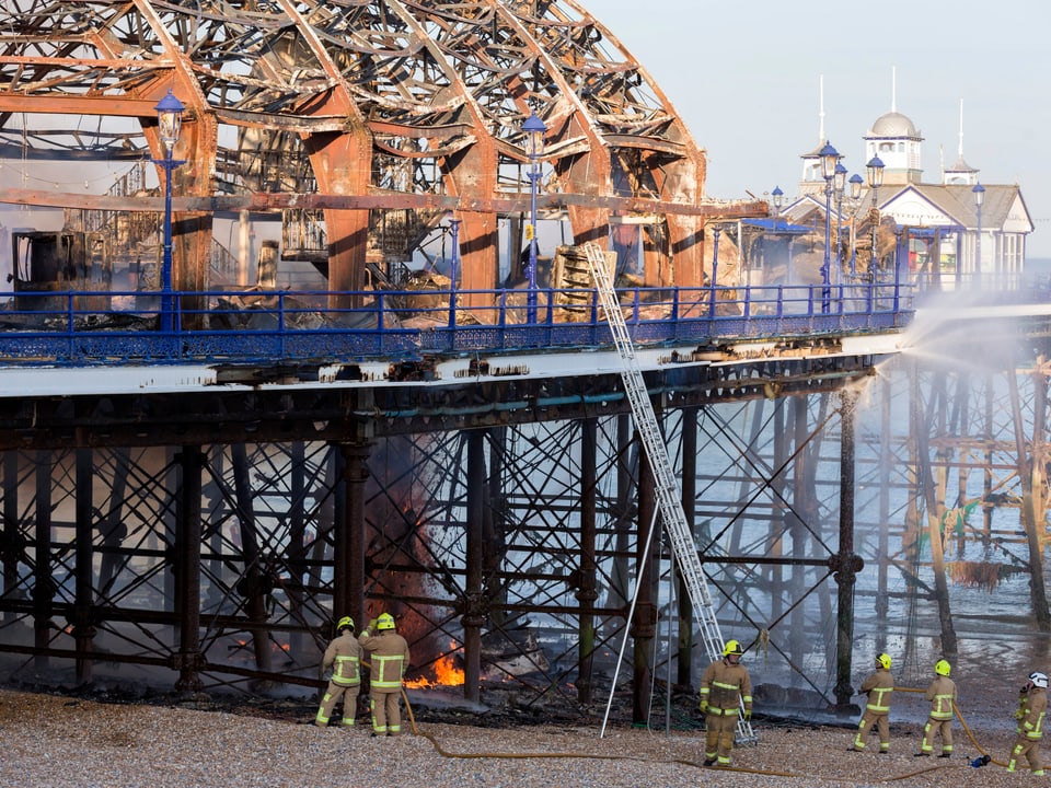 Der Pier vom Strand aus gesehen mit dem Skelett des abgebrannten Gebäudes.