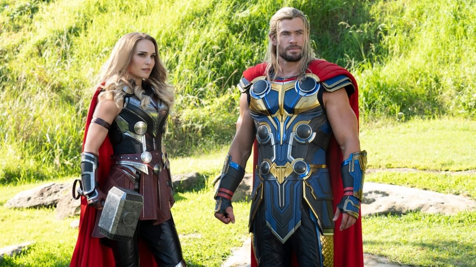 Natalie Portman im Thor-Kostüm mit Hammer steht neben Chris Hemsworth, ebenfalls als Thor.