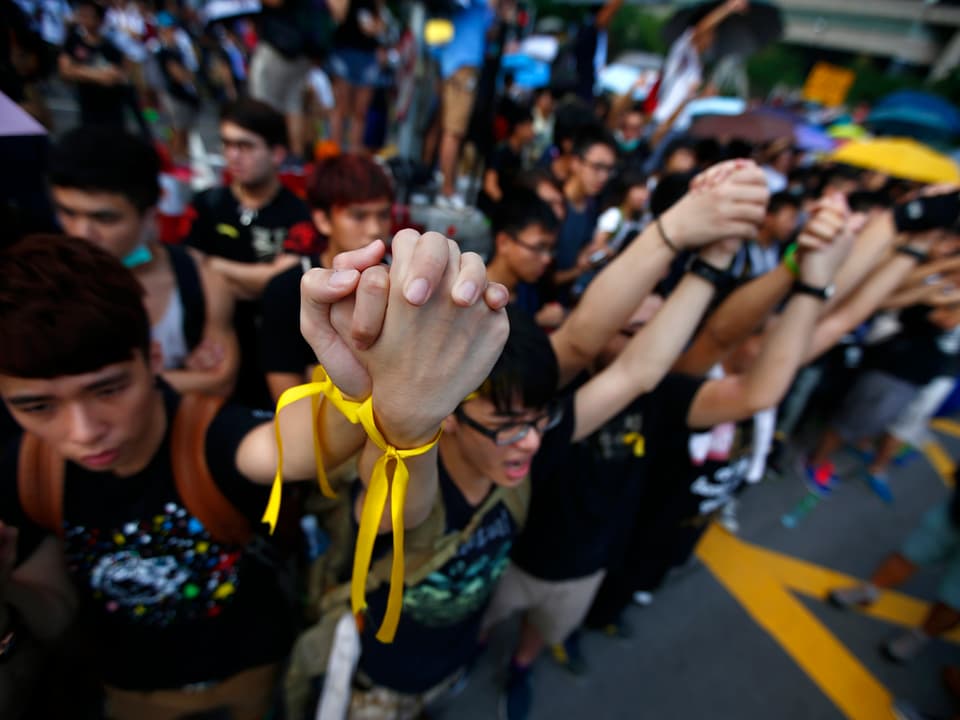 Demonstranten halten gemeinsam die Hände in die Höhe