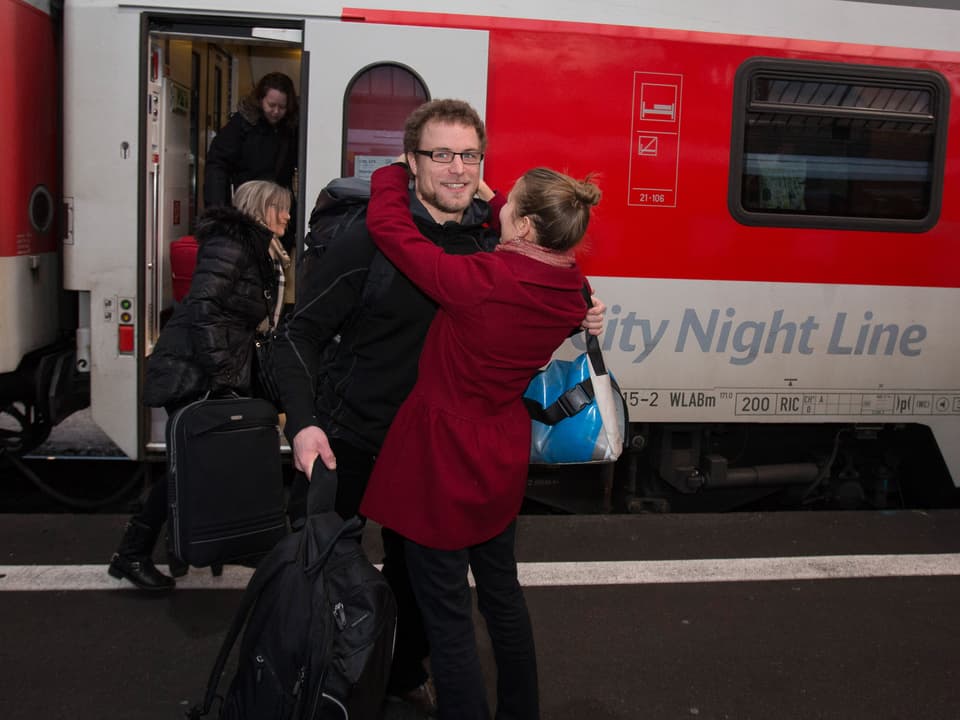 Marco Weber an einem Schweizr Bahnhof wird von einer blonden Frau umarmt. 