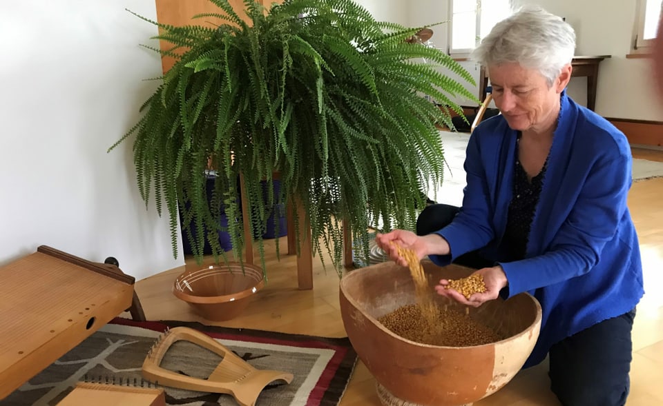 Musiktherapeutin Sandra Lutz macht mit Maiskörnern in einer Kalabasse Geräusche und Rhythmus.