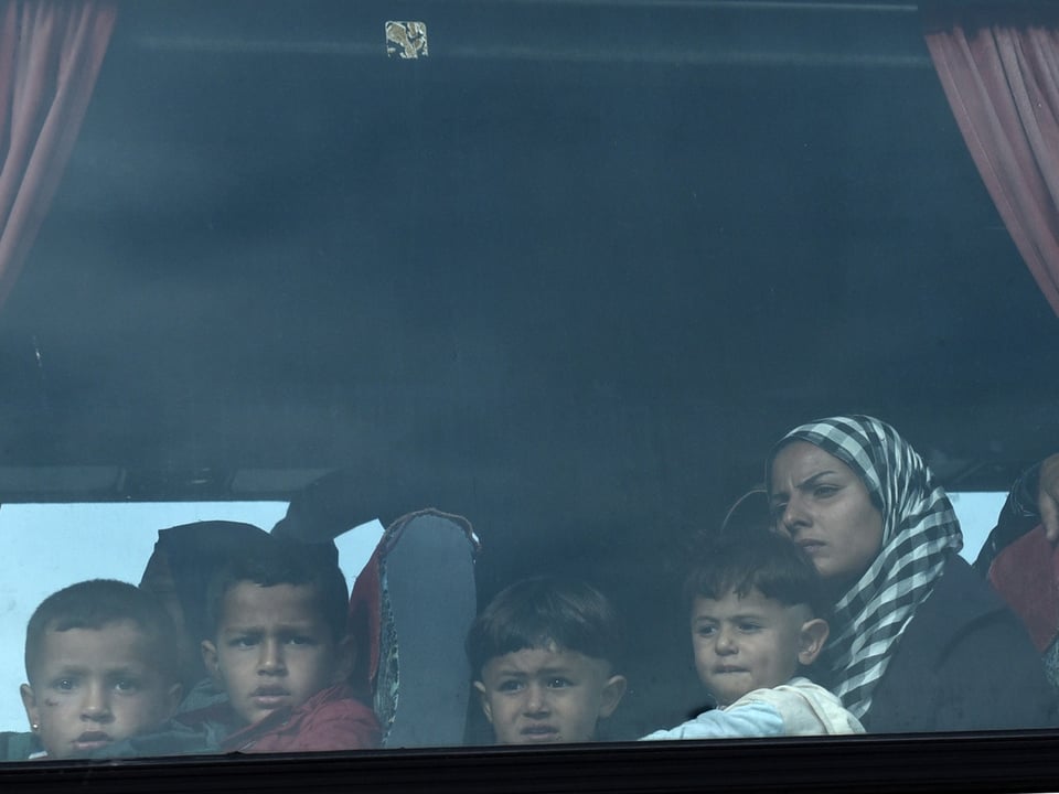Kinder und eine Frau in einem Bus durch das Fenster aufgenommen.