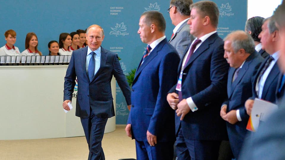 Putin läuft an mehreren Männern vorbei.