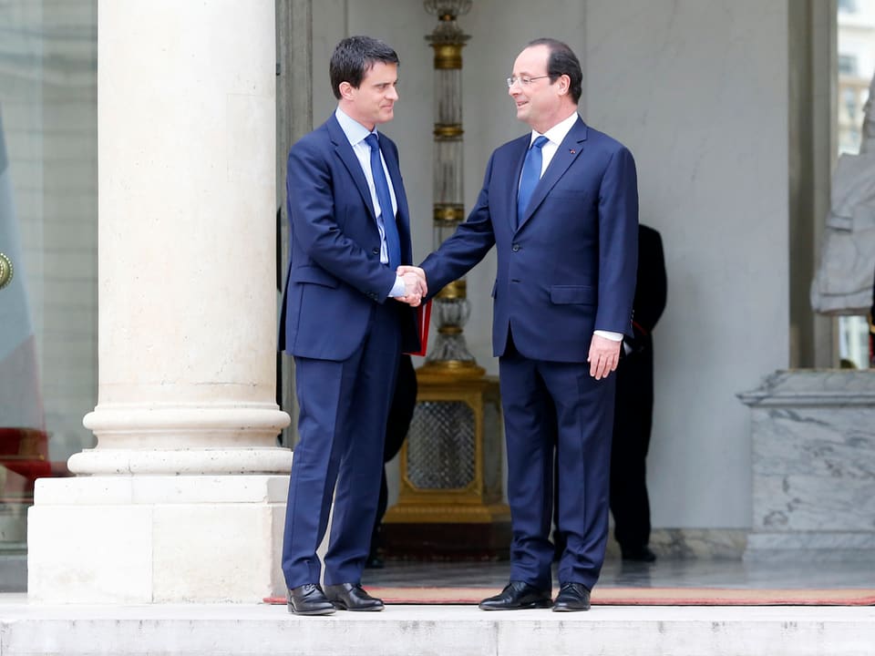 Manuel Valls (links) und François Hollande (rechts) schütteln sich die Hände.