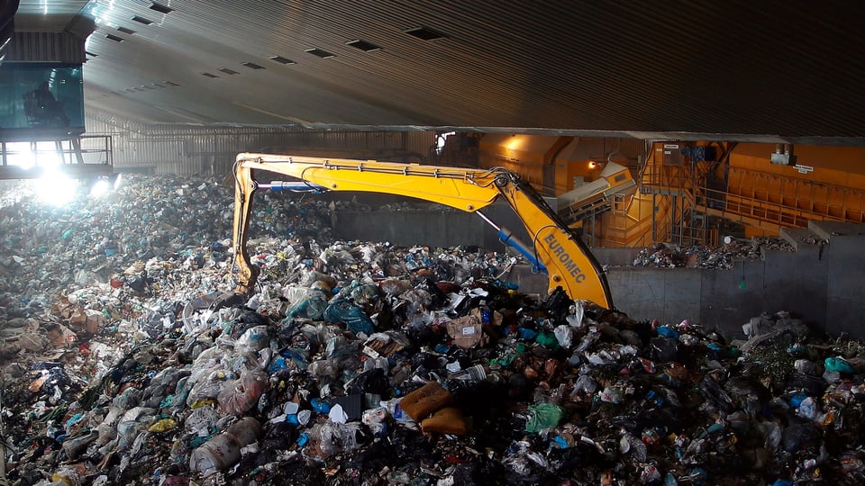 Greifarm wühlt im Abfall auf der Mülldeponie Malagrotta
