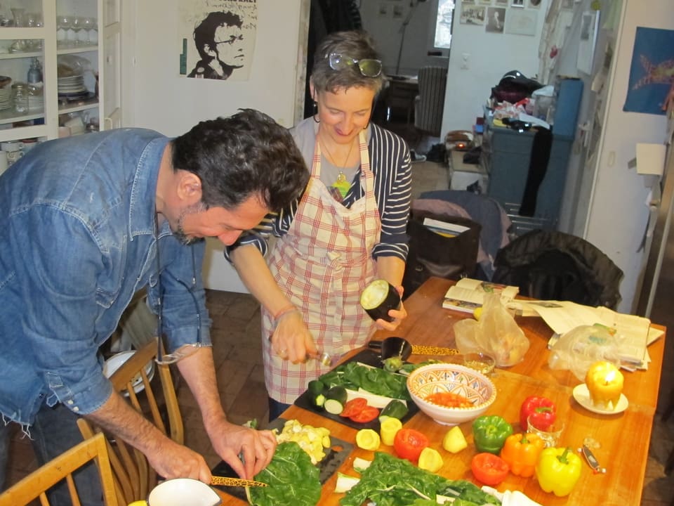 Khalid Ahmed und Séverine Vitali stehen am Küchetisch und bereiten das Gemüse vor