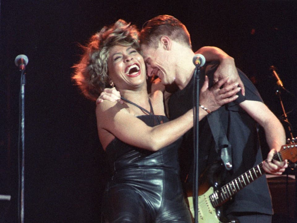 Tina Turner und Bryan Adams umarmen sich auf der Bühne
