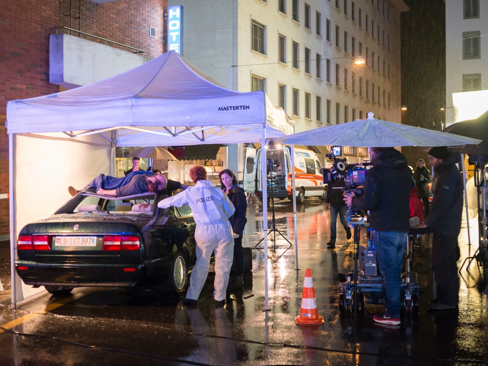 Einblick in die Dreharbeiten zu einer Folge von «Tatort»: Unter einem weissen Zelt steht ein Auto, auf dessen Dach eine Leiche liegt.