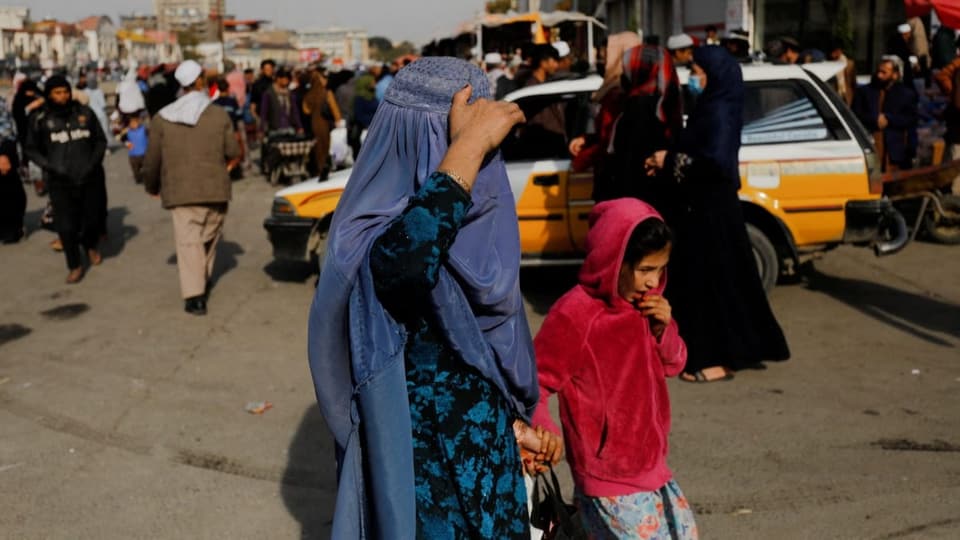 Afghanische Frau und Kind gehen in den Strassen von Kabul.