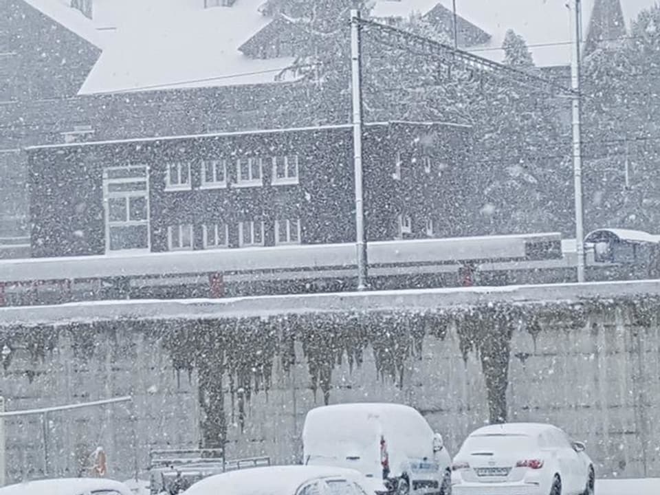 Grosse Schneeflocken an einem Bahnhof.