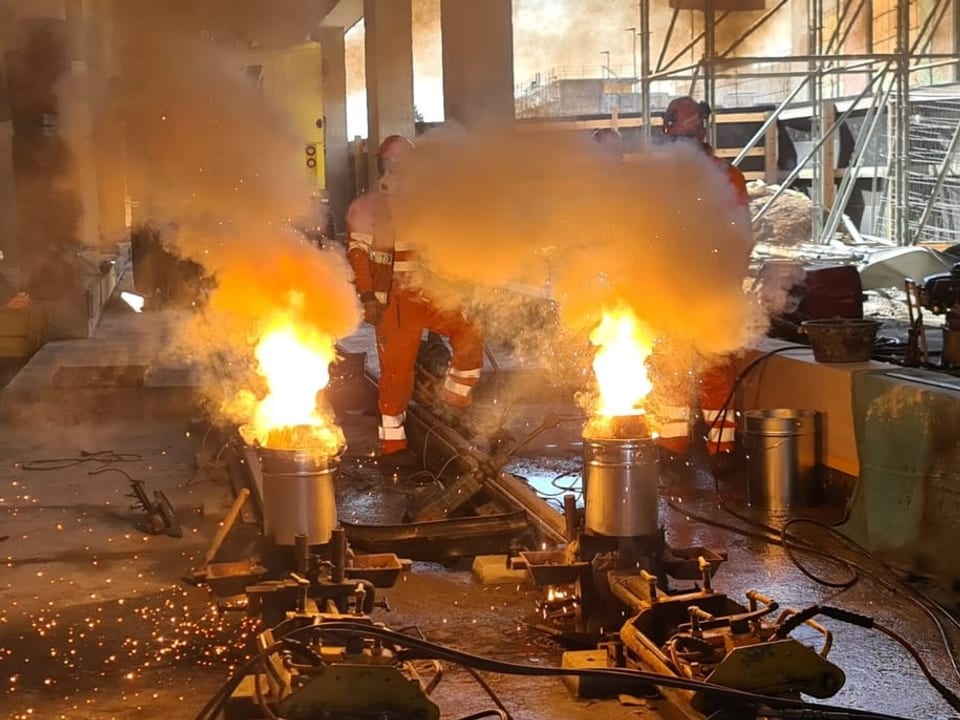 Feuer kommt aus Metallkübeln auf Geleisen.