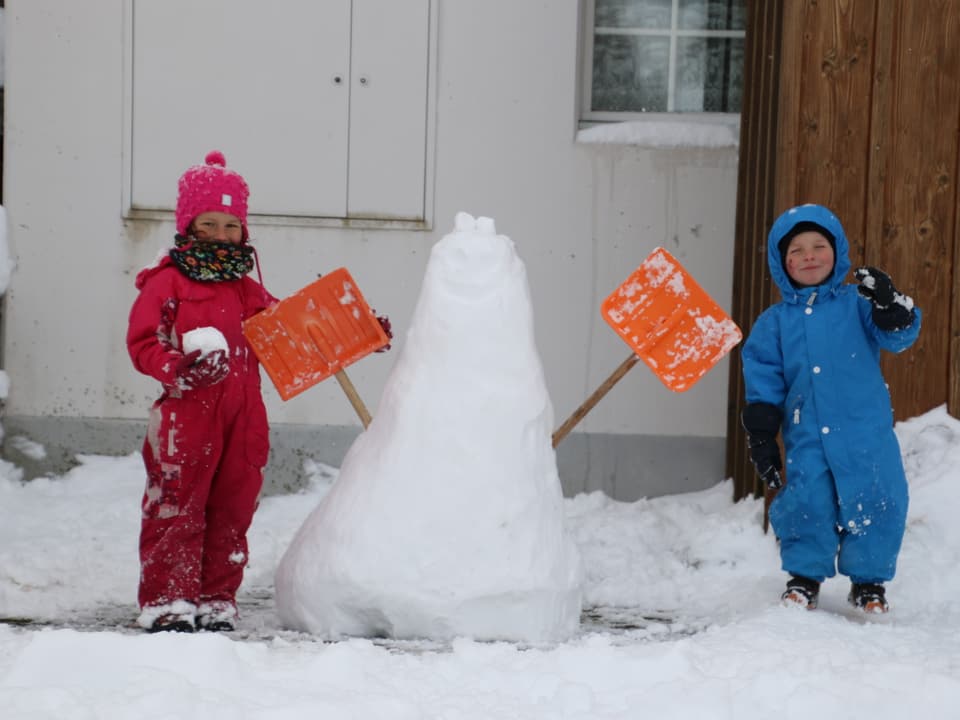 Zwei Kinder haben einen Schneemann gebaut.