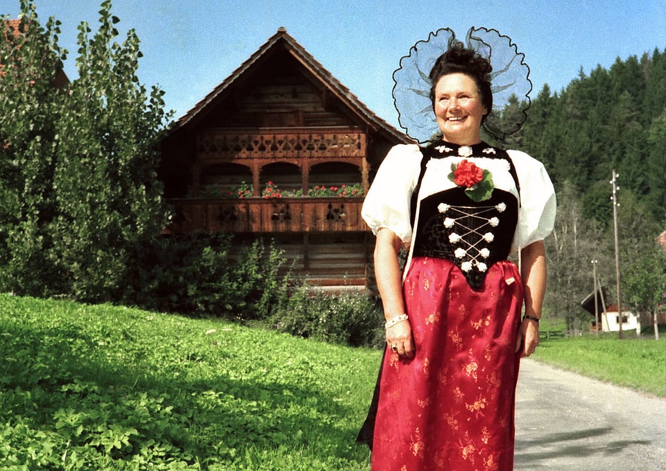 Vreni Kneubühl steht in der Tracht vor dem Waldhaus Lützelflüh.